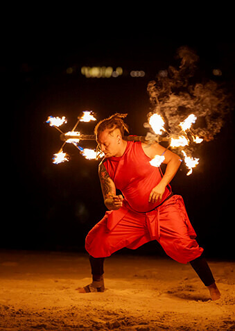 Атмосферное фаер-шоу на фоне черного неба и океана
